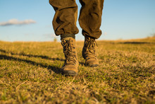 Travel Adventure. Future. Military Shoes. Male Feet In Green Boots. Hynter Searching For Victim In Grass Field. Going To Success. Freedom. Soldier Uniform. Step Up. Walking. Hiking And Camping