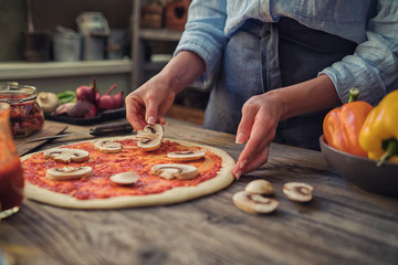 Wall Mural - Pizza art. The process of making pizza. Raw dough for pizza with ingredients and spices on table. Traditional Italian pizza and vegetables on a dark wooden background. Pizza menu. Soft focus.