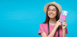 Horizontal banner of of smiling dreaming young female tourist holding flight tickets, isolated on blue background