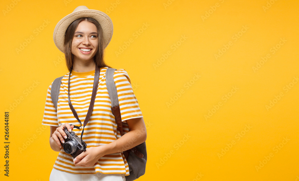 Horizontal banner of smiling young female tourist holding camera, isolated on yellow background with copy space - obrazy, fototapety, plakaty 