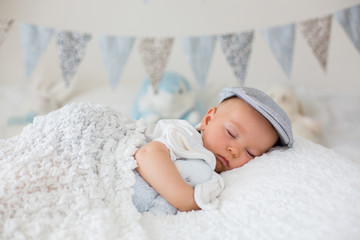 Wall Mural - Sweet little child, baby boy, sleeping in a sunny bedroom during the day, having a rest