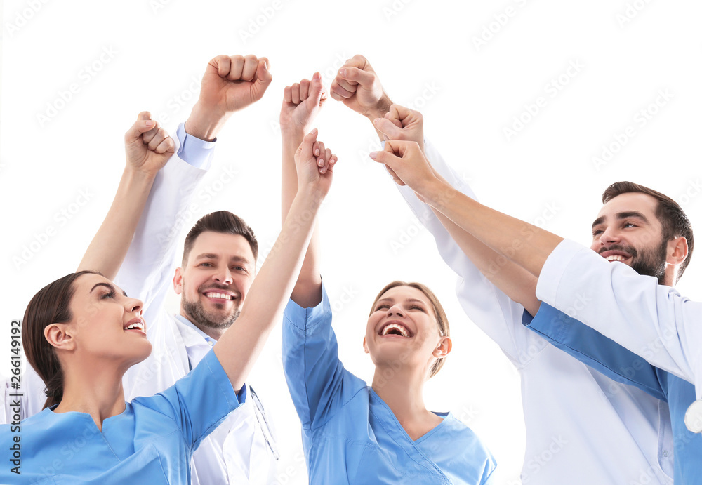 Team of medical doctors raising hands together on white background. Unity concept - obrazy, fototapety, plakaty 