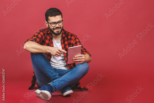 Portrait Of Young Man Sitting On The Floor Using A Tablet Pc