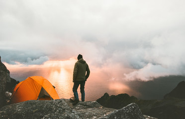 Wall Mural - Man traveling with tent camping on mountain top outdoor adventure lifestyle hiking active extreme summer vacations sunset and clouds view