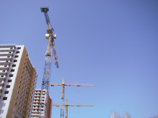 Two almost built high-rise buildings. Three construction cranes. Space for text.