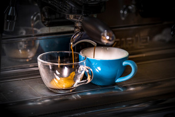 two cups of coffee on the coffee machine.