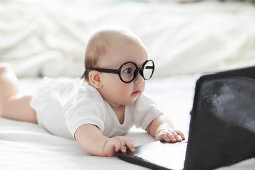 a newborn baby is lying on a soft bed in glasses.