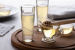 honey and mead in a glass on a wooden stand
