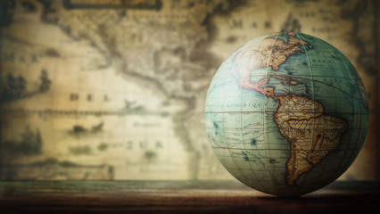 old globe on vintage map background. selective focus. travel, stories and education background.