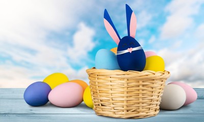 Wall Mural - Composition with Easter eggs  in nest and flowers , on wooden background