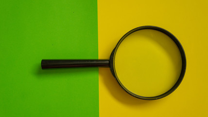 Magnifier glass on yellow and green background