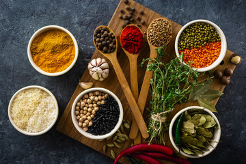 Poster - Spices and herbs, rice and various beans on dark background top view