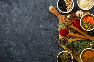 Poster - Spices, herbs, rice and various beans and seasonings for cooking on dark backgraund with copy space top view
