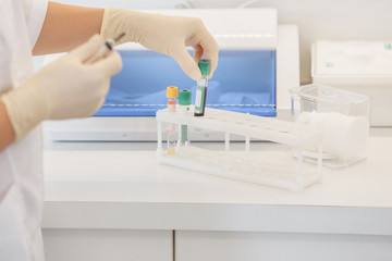 Doctor's hands take blood from a vein from a patient sitting in a chair. Blood test concept and detection of diseases