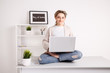 © burdun - Young woman in office meditating on the table with laptop