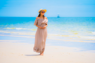 Portrait beautiful young asian woman smile happy walk on the tropical outdoor nature beach sea