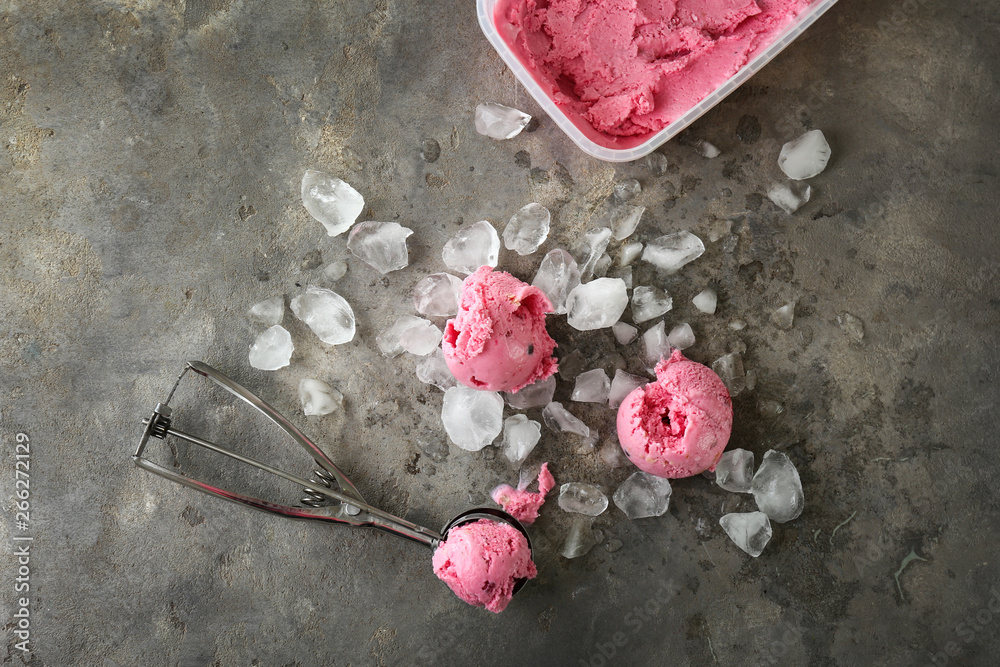 Tasty ice cream with spoon and ice on grunge background