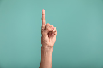 gesturing female hand on color background