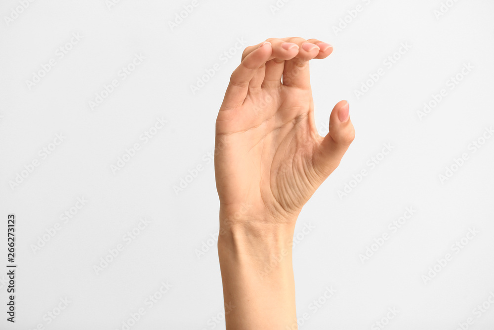 Female hand showing letter C on light background