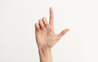 © Pixel-Shot - Female hand showing letter L on light background