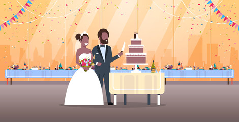 Wall Mural - just married man woman cutting sweet cake romantic african american couple bride groom in love wedding day concept modern restaurant interior full length horizontal flat