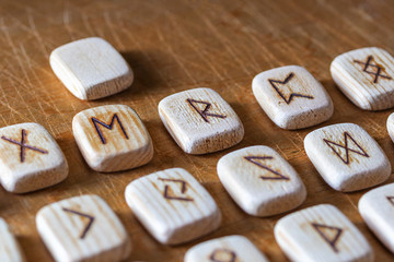 Wall Mural - Anglo-saxon wooden handmade runes on the vintage table On each rune symbol for fortune telling is designated.