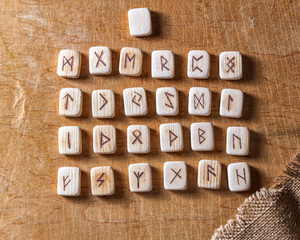 Wall Mural - Anglo-saxon wooden handmade runes on the vintage table On each rune symbol for fortune telling is designated.