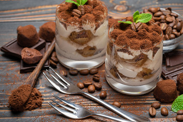 Wall Mural - two portions Classic tiramisu dessert in a glass on wooden background