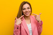 © Asier - Young fashion business woman smiles, pointing fingers at mouth.