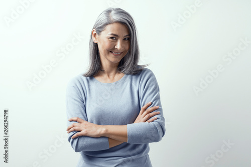 Beautiful Asian With White Hair Smiling Standing Near The Wall