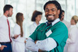 © Mediteraneo - Handsome african american medical doctor with colleagues in background