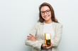 © Asier - Young european business woman holding a gold ingot smiling confident with crossed arms.