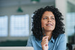 © mavoimages - Smiling young businesswoman deep in thought at her office desk