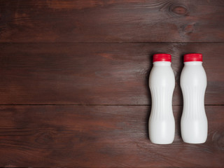 Two white plastic bottle on a wooden brown background