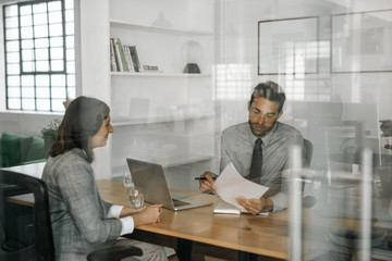 smiling manager reading an applicant's resume during an interview