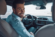 © gstockstudio - Are you ready to go? Rear view of young man in smart casual wear looking at camera over shoulder and smiling while driving a status car