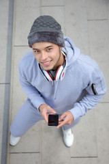 Wall Mural - Smiling young latin man runner portrait format winter sports training from above