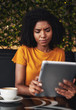 © StratfordProductions - Serious young woman using digital tablet in cafe
