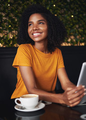 Wall Mural - Smiling young woman in cafe looking away