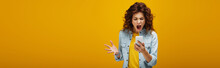 Panoramic Shot Of Angry Redhead Woman Gesturing While Looking At Smartphone And Screaming On Orange