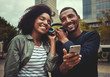 © StratfordProductions - Smiling young couple enjoying listening to music on one headphone