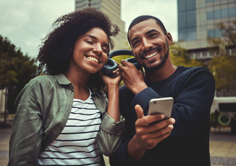 Smiling young couple enjoying listening to music on one headphone