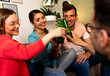 © Zoran Zeremski - Four friends making a beer toast at a home party.