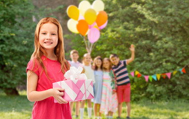 birthday and people concept - smiling red haired girl with gift box over party at summer park