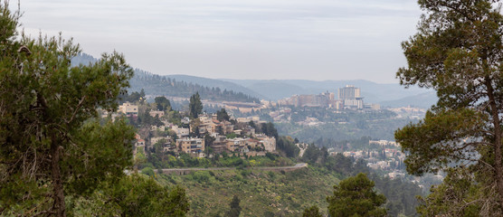 Beautiful view of residential homes on top of a hill in a city during a cloudy day. Taken in Jerusalem, Israel.