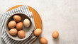 © The Picture Pantry - Brown and white eggs in a bowl on a textured grey background with copyspace.