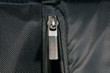 Zipper made of metal on a black backpack. Close-up view