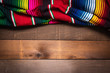 A mexican serape blanket on a wooden plank background