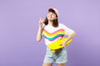 © ViDi Studio - Smiling teen girl in vivid clothes with yellow skateboard showing victory sign, keeping eyes closed isolated on violet pastel background. People sincere emotions lifestyle concept. Mock up copy space.