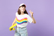 © ViDi Studio - Charming teen girl in vivid clothes looking aside, holding yellow skateboard, showing victory sign isolated on violet pastel background. People sincere emotions, lifestyle concept. Mock up copy space.